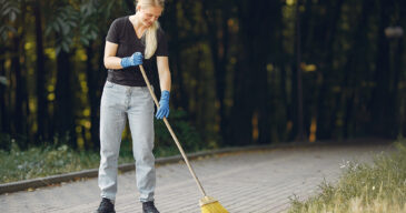 Volunteer collects leaves. Woman in a park. People cleans the park